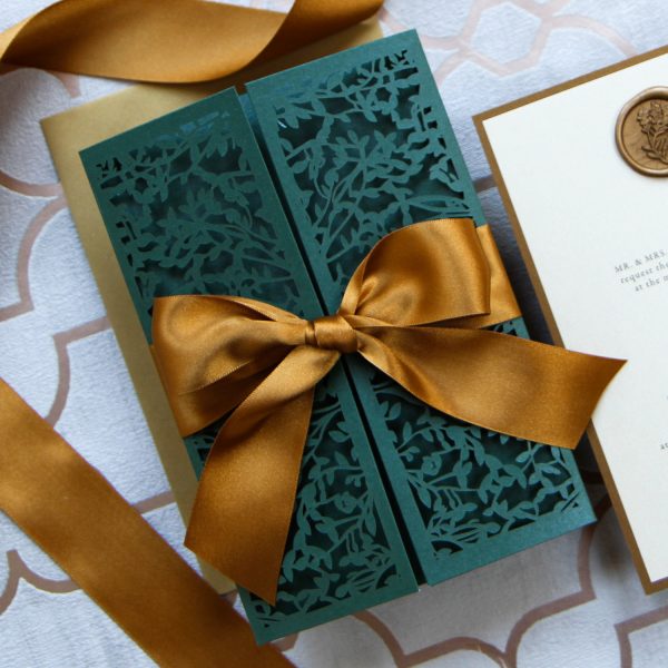 Forest green laser cut invitation with gold ribbon